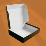 Black corrugated mailer box open with folded clothing inside